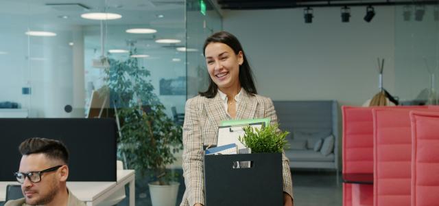 Woman carrying box of belongings leaving office by Vitaly Gariev courtesy of Unsplash.